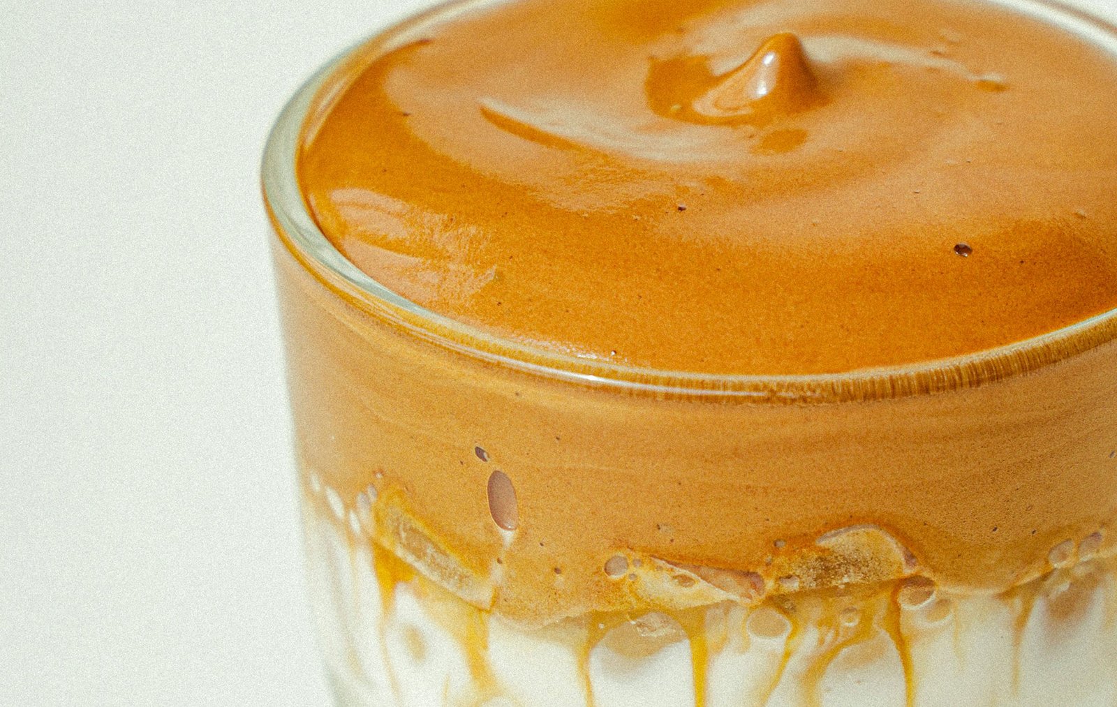 Creamy Peanut Butter Smoothie in Glass Thick peanut butter smoothie in a clear glass with whipped texture and ice